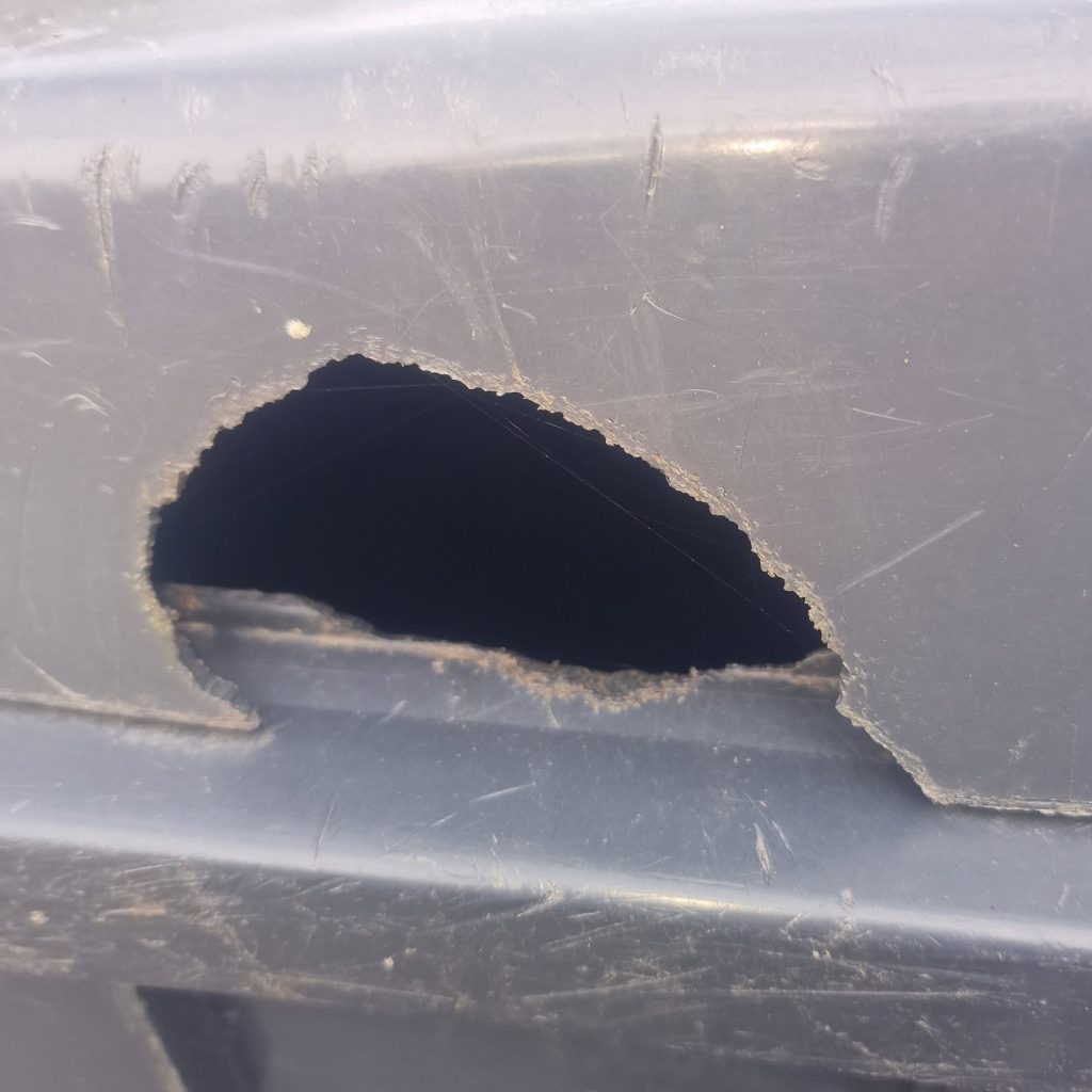 A grey bin with a bite mark in it 